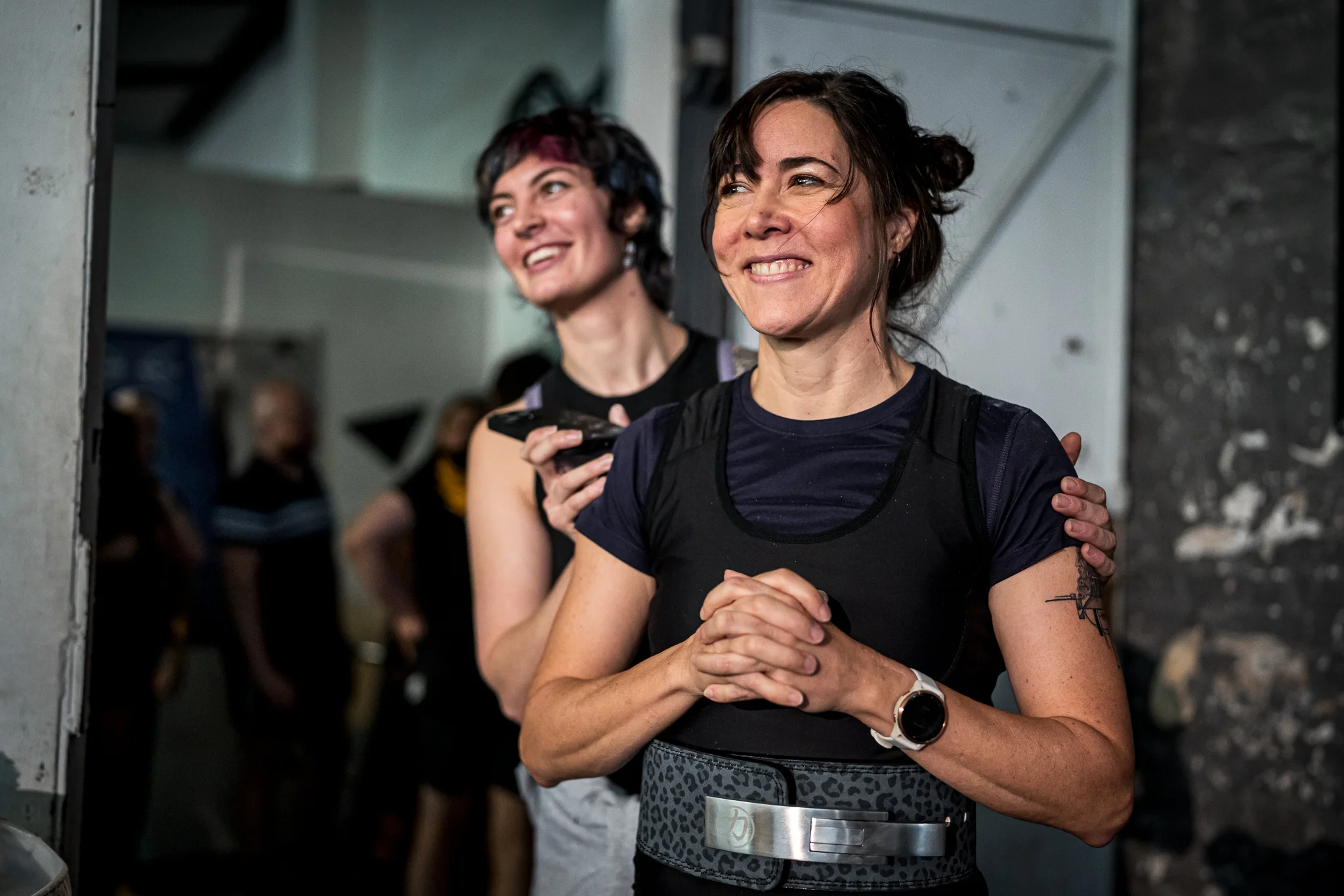 Zwei Athletinnen stehen lachend im Aufwärmbereich