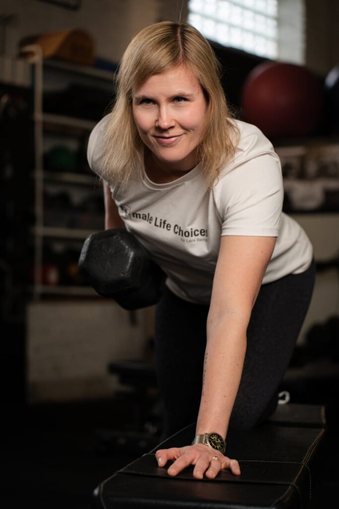 portrait of a woman lifting weights in a gym